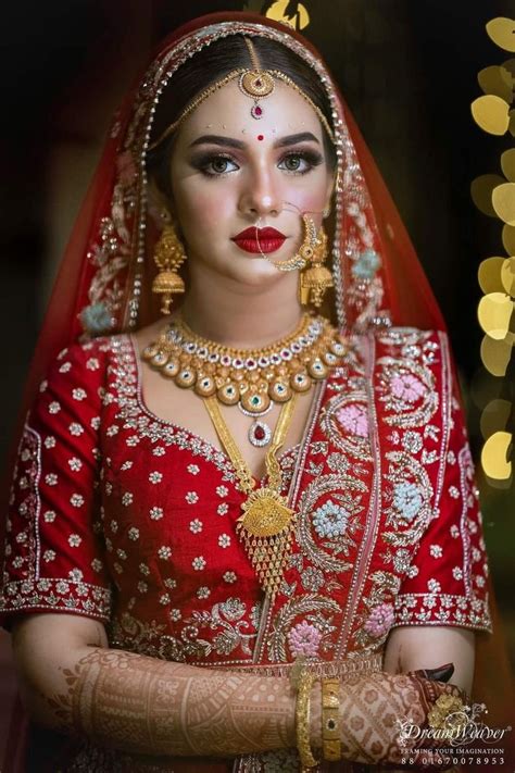 A Woman Wearing A Red And Gold Bridal Outfit With Her Hands On Her Chest