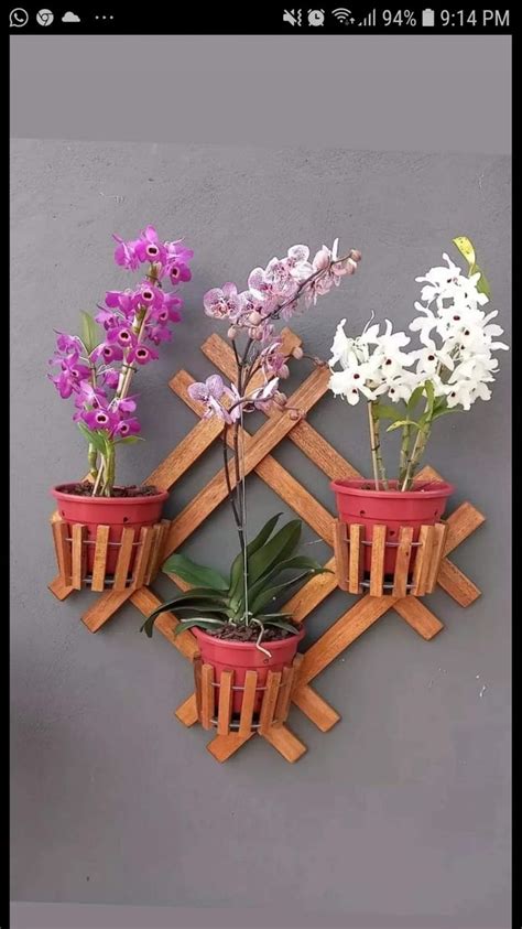 Three Potted Plants Are Mounted To A Wall