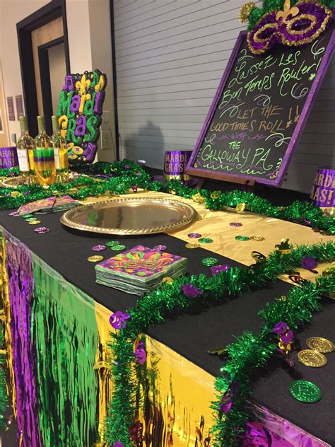 A Mardi Gras Table Is Decorated With Green And Purple Decorations