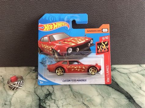 A Red Hot Wheels Car With Flames On The Front And Sides Sitting On A Marble Countertop