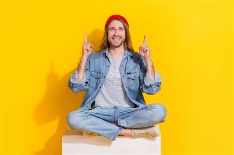 Photo Of Dreamy Funny Guy Dressed Jeans Shirt Looking Pointing Two Fingers Up Emtpy Space Yellow