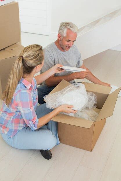 Premium Photo Happy Couple Unpacking Cardboard Moving Boxes