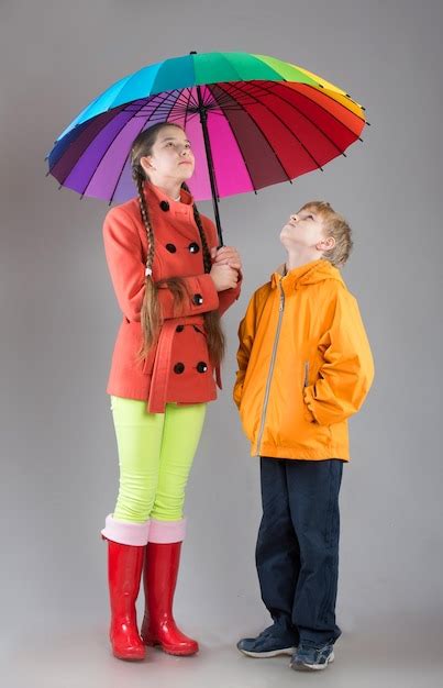 Premium Photo Boy And Girl With A Colorful Umbrella Looking Up Studio