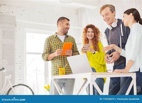 Quatro Colegas Alegres Que Confundem Do Trabalho Foto De Stock Imagem