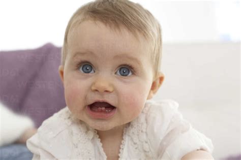 Portrait Of Baby Girl With Open Mouth Showing First Teeth Stock Photo