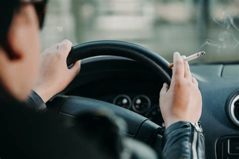 Premium Photo Close Up Of Woman Hand Smoking Cigarette Inside The Car