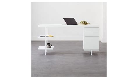 A Laptop Computer Sitting On Top Of A Desk Next To A White Drawer And Shelf