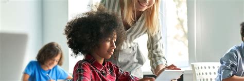 Teacher and student use a tablet in the classroom.