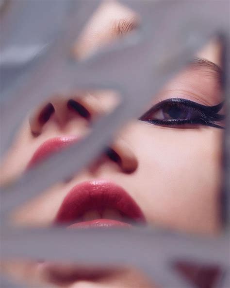 A Womans Face Is Seen Through The Metal Bars In Front Of Her Eyes