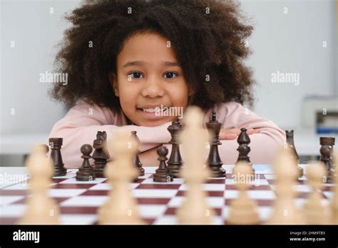 African American girl playing chess. Happy smiling child behind chess ...