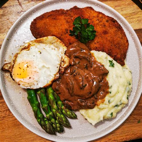 Schnitzel With Mashed Potatoes Steamed Asparagus Fried Egg And Mushroom Sauce Made In The