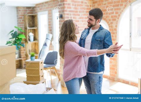 Young Couple Dancing Celebrating Moving To New Apartment Around