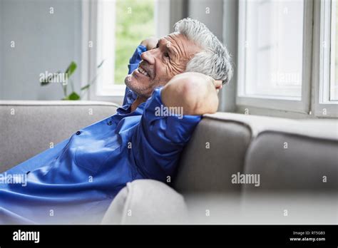 Relaxed Mature Man Sitting On Couch At Home Stock Photo Alamy