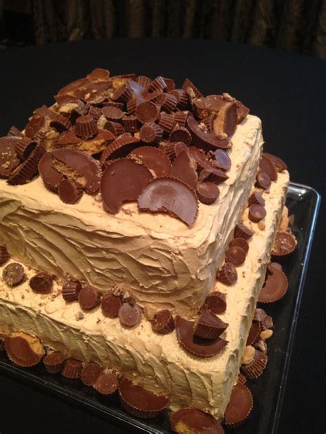 A Cake With Chocolate Chips On It Sitting On Top Of A Glass Platter In Front Of A Black Table