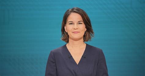 A Woman Is Standing In Front Of A Blue Background