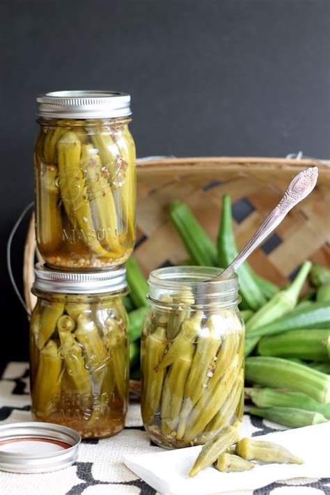 three jars filled with pickles sitting on top of a table