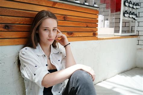 Jolie fille blonde assise sur le sol dans un café et regardant au loin Photo Premium