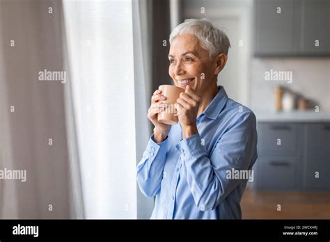 Mature Gray Lady With Haircut Sips Tea Holding Cup Indoor Stock Photo Alamy