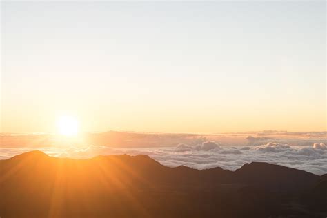 Sun Rising Above The Silhouette Of A Mountain Range Sunrise Over