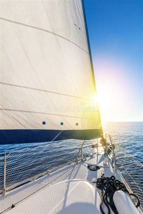 Sail Boat Yacht With Set Up Sails Gliding In Open Sea With Sun Stock