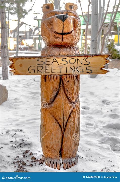 Escultura Da Madeira Do Urso Em Uma Paisagem Coberta A Neve Branca