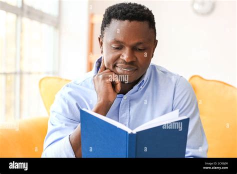 African American Man Reading Book At Home Stock Photo Alamy