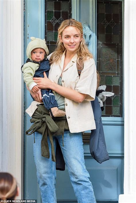 Dishevelled Jodie Comer comforts a baby while filming new dystopian ...