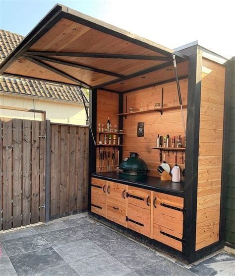 An Outdoor Kitchen Is Built Into The Side Of A House With Wooden