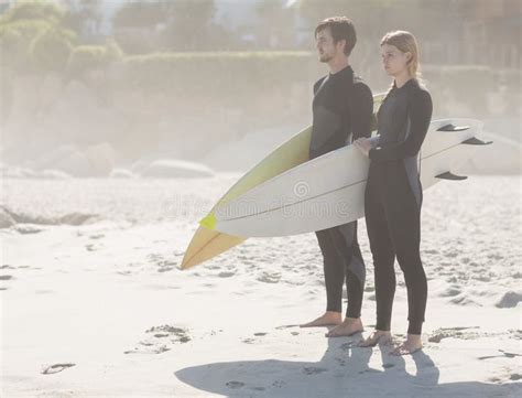 Couple With Surfboard Standing On The Beach Stock Image Image Of