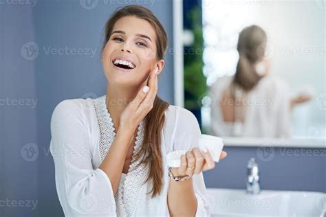 Beautiful Brunette Woman Applying Face Cream In The Bathroom 15767764 Stock Photo At Vecteezy