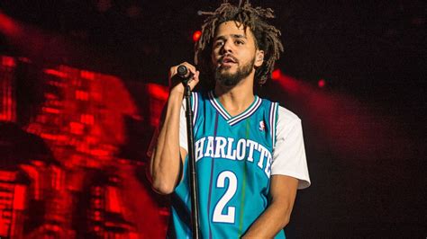 J Cole Is Wearing Blue White T Shirt Standing In Red Black Background