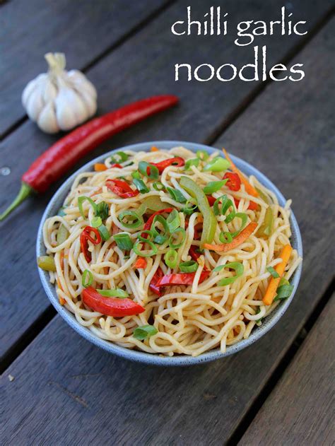 A Bowl Filled With Noodles And Vegetables On Top Of A Wooden Table Next