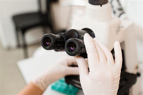 Laboratory Assistant Looks Into Microscope And Makes Blood Test In The