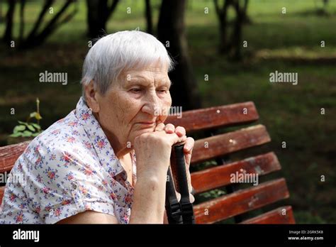 Vieille Femme Assise Sur Un Banc De Parc Banque De Photographies Et D