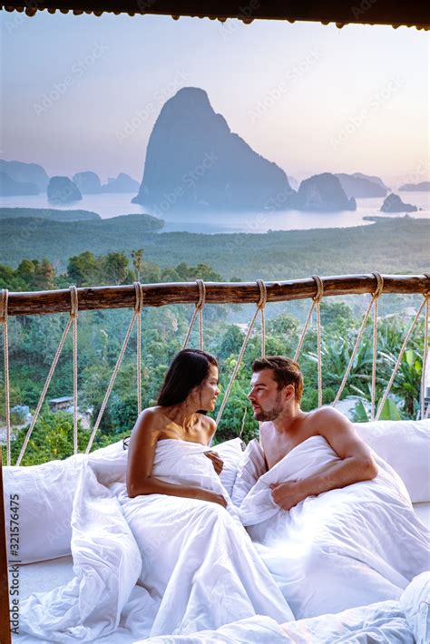 Couple Waking Up In Bed In Nature Jungle Looking Out Over Ocean During