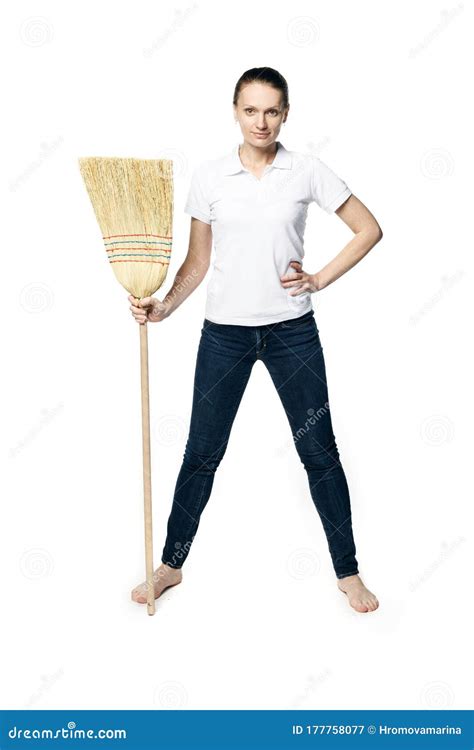 Beautiful Woman In A White T Shirt Posing Holding A Broom In Her Hands