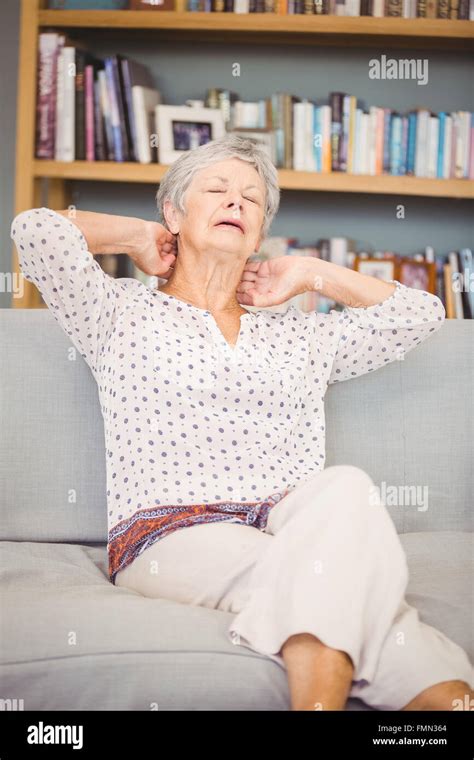 Senior Woman Suffering From Neck Pain On Sofa Stock Photo Alamy