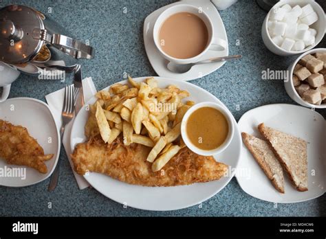 Authentic British fish and chips, with curry sauce, buttered bread and ...