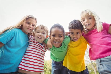 Camarades De Classe Avec Des Bras Autour Au Campus D école Image stock