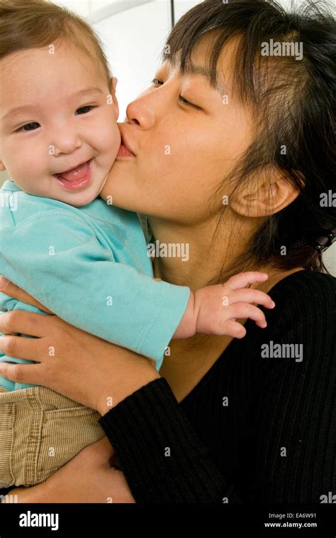 Young Korean Mother Kissing Mixed Race Asian Caucasian Baby Girl