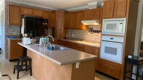 a kitchen with wooden cabinets and an island in the middle is seen from ...