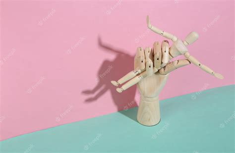 Premium Photo Wooden Hand Holding Puppet On Blue Pink Pastel