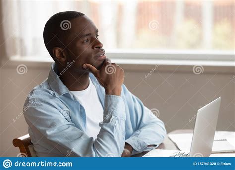 Pensive Biracial Man Distracted From Laptop Work Thinking Stock Photo