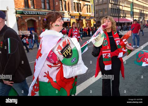 Wales Rugby Fans With Welsh Red Dragon Flags And Scarves On Street In