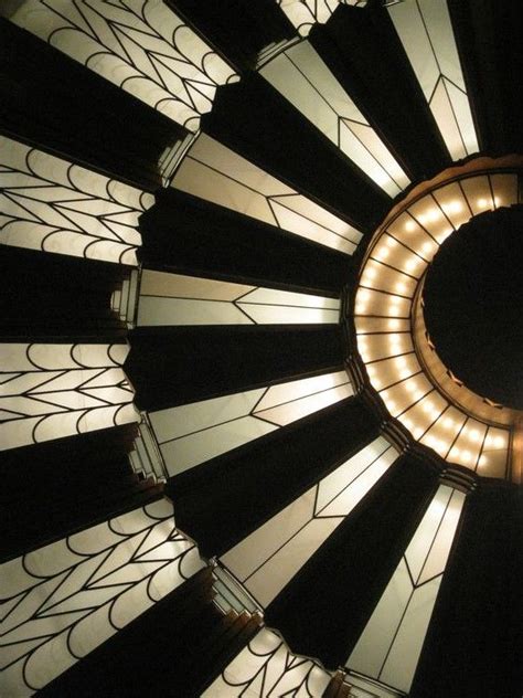 A Circular Light Fixture With Stained Glass Panels And Lights On Each