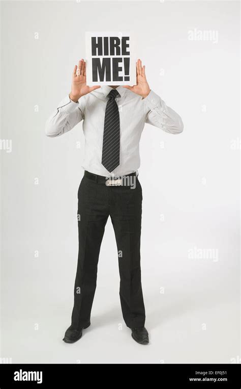 Man Holding A Hire Me Sign In Front Of His Face Stock Photo Alamy