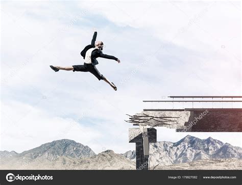 Woman jumping over huge gap Stock Photo by ©Khakimullin 179927082