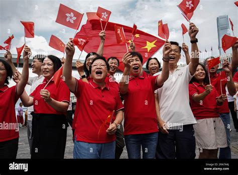 People Wave Both The Flags Of China And Hong Kong At A Handover Celebration At Tsim Sha Tsui On