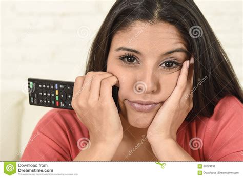 Young Beautiful Hispanic Woman At Home Watching Television Tired And