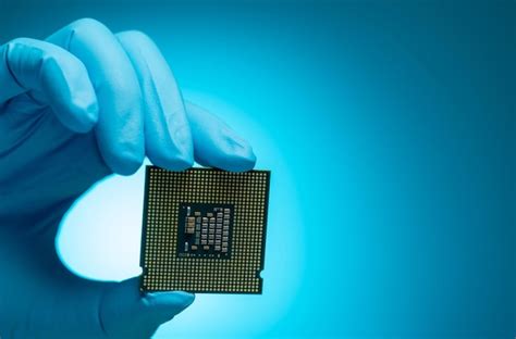 Ingeniero electrónico mano sosteniendo chip de computadora fondo azul